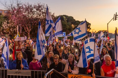 Hayfa, İsrail - Nisan 05, 2025: Çeşitli tabela ve bayraklara sahip bir grup insan, savaşın sona ermesi, rehine anlaşmasının tamamlanması ve yeni seçimler için düzenlenen protesto mitingine katıldı. Hayfa, İsrail