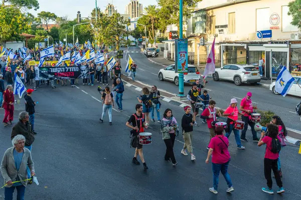Hayfa, İsrail - Nisan 05, 2025: Çeşitli tabela ve bayraklara sahip insanlar savaşın sona ermesi, rehine anlaşmasının tamamlanması ve yeni seçimler için düzenlenen protesto mitingine katıldılar. Hayfa, İsrail