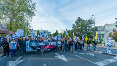 Hayfa, İsrail - Nisan 05, 2025: Çeşitli tabela ve bayraklara sahip insanlar savaşın sona ermesi, rehine anlaşmasının tamamlanması ve yeni seçimler için düzenlenen protesto mitingine katıldılar. Hayfa, İsrail