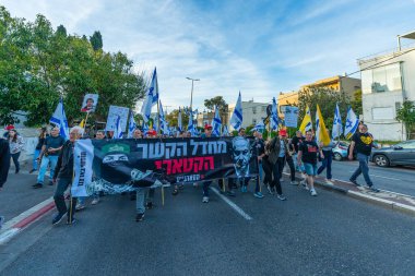 Hayfa, İsrail - Nisan 05, 2025: Çeşitli tabela ve bayraklara sahip insanlar savaşın sona ermesi, rehine anlaşmasının tamamlanması ve yeni seçimler için düzenlenen protesto mitingine katıldılar. Hayfa, İsrail