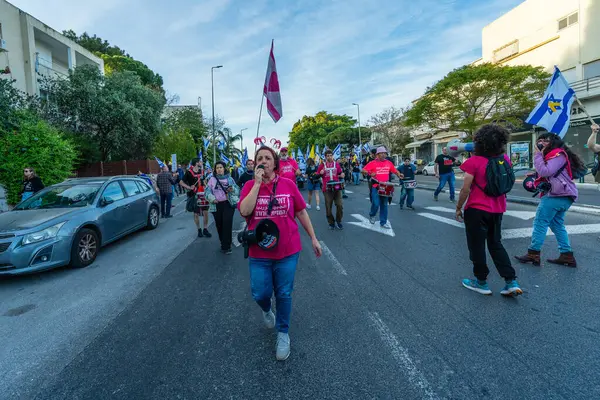 Hayfa, İsrail - Nisan 05, 2025: İnsanlar savaşın sona ermesi, rehine anlaşmasının tamamlanması ve yeni seçimler çağrısında bulunan bir protesto yürüyüşüne (Pembe Cephe Grubu) katılıyor. Hayfa, İsrail