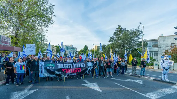 Hayfa, İsrail - Nisan 05, 2025: Çeşitli tabela ve bayraklara sahip insanlar savaşın sona ermesi, rehine anlaşmasının tamamlanması ve yeni seçimler için düzenlenen protesto mitingine katıldılar. Hayfa, İsrail