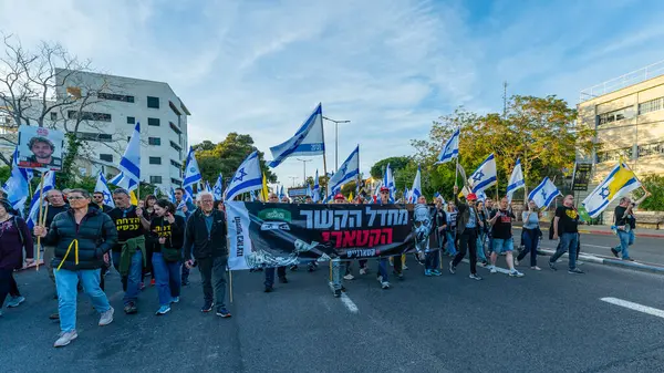 Hayfa, İsrail - Nisan 05, 2025: Çeşitli tabela ve bayraklara sahip insanlar savaşın sona ermesi, rehine anlaşmasının tamamlanması ve yeni seçimler için düzenlenen protesto mitingine katıldılar. Hayfa, İsrail