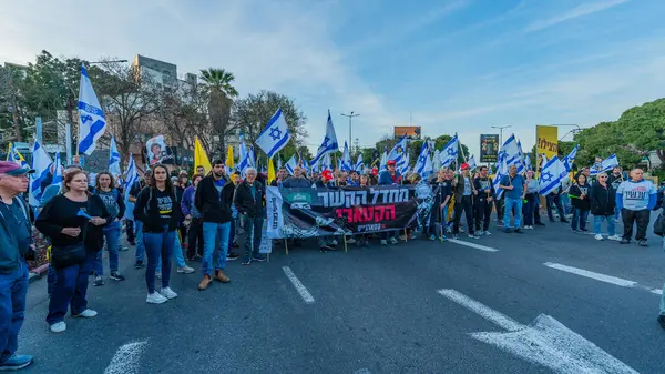 Hayfa, İsrail - Nisan 05, 2025: Çeşitli tabela ve bayraklara sahip insanlar savaşın sona ermesi, rehine anlaşmasının tamamlanması ve yeni seçimler için düzenlenen protesto mitingine katıldılar. Hayfa, İsrail