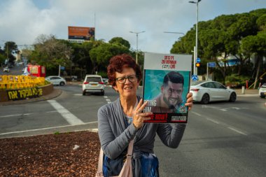 Hayfa, İsrail - 09 Nisan 2025: Tabela ve bayraklı insanların günlük protesto gösterileri, rehineleri desteklemek ve anlaşmanın Hayfa, İsrail 'de tamamlanması yönünde çağrıda bulunmaları