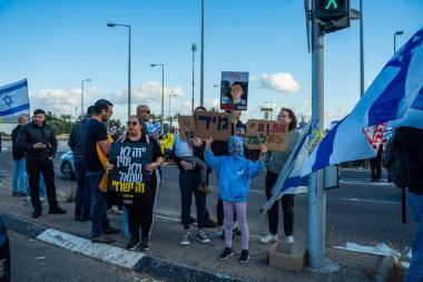 Ein HaMifratz, İsrail - 10 Nisan 2025: Rehine posterleri ve diğer tabelaları olan insanlar, otoyolun yakınında, rehinelere destek çağrısında bulunuyorlar ve anlaşmanın tamamlanmasını istiyorlar, Ein HaMifratz, İsrail