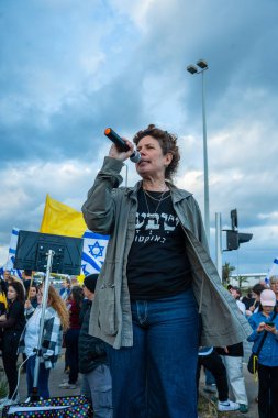 Ein HaMifratz, İsrail - 10 Nisan 2025: Rehine posterleri ve diğer tabelaları olan insanlar, otoyolun yakınında, rehinelere destek çağrısında bulunuyorlar ve anlaşmanın tamamlanmasını istiyorlar, Ein HaMifratz, İsrail