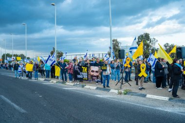 Ein HaMifratz, İsrail - 10 Nisan 2025: Rehine posterleri ve diğer tabelaları olan insanlar, otoyolun yakınında, rehinelere destek çağrısında bulunuyorlar ve anlaşmanın tamamlanmasını istiyorlar, Ein HaMifratz, İsrail