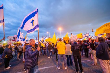 Ein HaMifratz, İsrail - 10 Nisan 2025: Rehine posterleri ve diğer tabelaları olan insanlar, otoyolun yakınında, rehinelere destek çağrısında bulunuyorlar ve anlaşmanın tamamlanmasını istiyorlar, Ein HaMifratz, İsrail