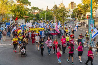 Hayfa, İsrail - 19 Nisan 2025: Çeşitli tabelaları ve bayrakları olan insanlar, savaşın sona ermesi, rehine anlaşmasının tamamlanması ve yeni seçimlerin başlatılması için düzenlenen protesto mitingine katıldılar. Hayfa, İsrail