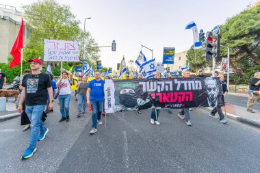 Hayfa, İsrail - 19 Nisan 2025: Çeşitli tabelaları ve bayrakları olan insanlar, savaşın sona ermesi, rehine anlaşmasının tamamlanması ve yeni seçimlerin başlatılması için düzenlenen protesto mitingine katıldılar. Hayfa, İsrail