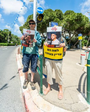 Hayfa, İsrail - 25 Nisan 2025: Tabela ve bayraklı insanların günlük protesto gösterileri, rehineleri desteklemek, anlaşmanın Hayfa, İsrail 'de tamamlanması yönünde çağrıda bulunmaları