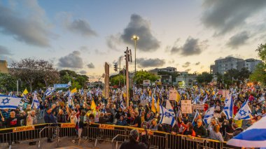 Hayfa, İsrail - 26 Nisan 2025: Çeşitli tabela ve bayraklara sahip bir grup insan, savaşın sona ermesi, rehine anlaşmasının tamamlanması ve yeni seçimler için düzenlenen protesto mitingine katıldı. Hayfa, İsrail