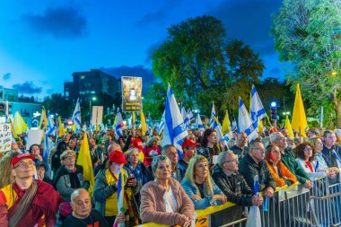 Hayfa, İsrail - 26 Nisan 2025: Çeşitli tabela ve bayraklara sahip bir grup insan, savaşın sona ermesi, rehine anlaşmasının tamamlanması ve yeni seçimler için düzenlenen protesto mitingine katıldı. Hayfa, İsrail
