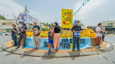 Hayfa, İsrail - 30 Nisan 2025: İnsanlar Anma Günü 'nde rehineleri protesto ederek ve destekleyerek, anlaşmanın tamamlanması için çağrıda bulunarak rehin posterleriyle sessizce duruyorlar. Hayfa, İsrail
