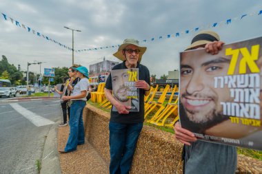 Hayfa, İsrail - 30 Nisan 2025: İnsanlar Anma Günü 'nde rehineleri protesto ederek ve destekleyerek, anlaşmanın tamamlanması için çağrıda bulunarak rehin posterleriyle sessizce duruyorlar. Hayfa, İsrail