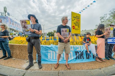Hayfa, İsrail - 30 Nisan 2025: İnsanlar Anma Günü 'nde rehineleri protesto ederek ve destekleyerek, anlaşmanın tamamlanması için çağrıda bulunarak rehin posterleriyle sessizce duruyorlar. Hayfa, İsrail