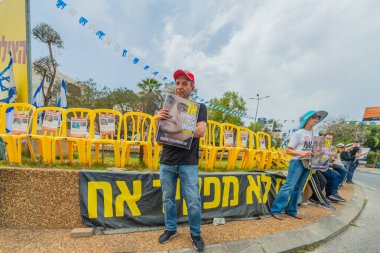 Hayfa, İsrail - 30 Nisan 2025: İnsanlar Anma Günü 'nde rehineleri protesto ederek ve destekleyerek, anlaşmanın tamamlanması için çağrıda bulunarak rehin posterleriyle sessizce duruyorlar. Hayfa, İsrail