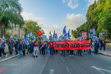 Hayfa, İsrail - 3 Mayıs 2025: Çeşitli tabelaları ve bayrakları olan insanlar, savaşın sona ermesi, rehine anlaşmasının tamamlanması ve yeni seçimler için düzenlenen protesto mitingine katıldılar. Hayfa, İsrail