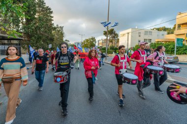 Hayfa, İsrail - 3 Mayıs 2025: İnsanlar savaşın sona ermesi, rehine anlaşmasının tamamlanması ve yeni seçimler için çağrıda bulunan bir protesto yürüyüşüne (Pembe Cephe Grubu) katıldı. Hayfa, İsrail