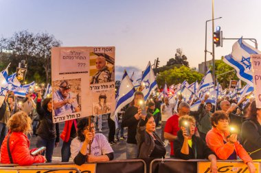 Hayfa, İsrail - 3 Mayıs 2025: Çeşitli tabela ve bayraklara sahip bir grup insan, savaşın sona ermesi, rehine anlaşmasının tamamlanması ve yeni seçimler için düzenlenen protesto mitingine katıldı. Hayfa, İsrail