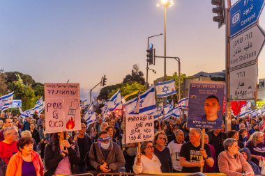 Hayfa, İsrail - 3 Mayıs 2025: Çeşitli tabela ve bayraklara sahip bir grup insan, savaşın sona ermesi, rehine anlaşmasının tamamlanması ve yeni seçimler için düzenlenen protesto mitingine katıldı. Hayfa, İsrail