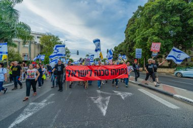 Hayfa, İsrail - 10 Mayıs 2025: Çeşitli tabelaları ve bayrakları olan insanlar, savaşın sona ermesi, rehine anlaşmasının tamamlanması ve yeni seçimlerin başlatılması için düzenlenen protesto mitingine katıldılar. Hayfa, İsrail