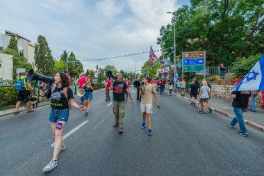 Hayfa, İsrail - 10 Mayıs 2025: Çeşitli tabelaları ve bayrakları olan insanlar, savaşın sona ermesi, rehine anlaşmasının tamamlanması ve yeni seçimlerin başlatılması için düzenlenen protesto mitingine katıldılar. Hayfa, İsrail