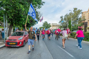 Hayfa, İsrail - 10 Mayıs 2025: İnsanlar savaşın sona ermesi, rehine anlaşmasının tamamlanması ve yeni seçimler çağrısında bulunan bir protesto yürüyüşüne (Pembe Cephe Grubu) katılıyor. Hayfa, İsrail