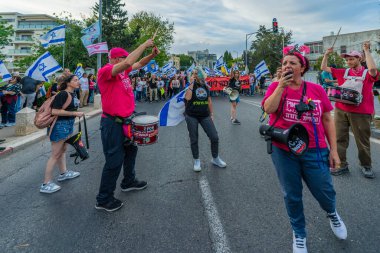 Hayfa, İsrail - 10 Mayıs 2025: İnsanlar savaşın sona ermesi, rehine anlaşmasının tamamlanması ve yeni seçimler çağrısında bulunan bir protesto yürüyüşüne (Pembe Cephe Grubu) katılıyor. Hayfa, İsrail
