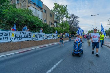 Hayfa, İsrail - 10 Mayıs 2025: Çeşitli tabelaları ve bayrakları olan insanlar, savaşın sona ermesi, rehine anlaşmasının tamamlanması ve yeni seçimlerin başlatılması için düzenlenen protesto mitingine katıldılar. Hayfa, İsrail