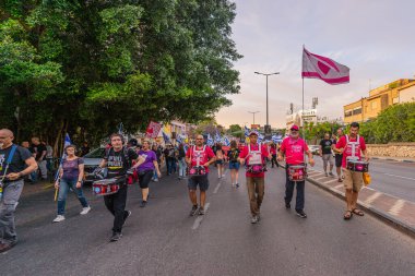 Hayfa, İsrail - 10 Mayıs 2025: İnsanlar savaşın sona ermesi, rehine anlaşmasının tamamlanması ve yeni seçimler çağrısında bulunan bir protesto yürüyüşüne (Pembe Cephe Grubu) katılıyor. Hayfa, İsrail