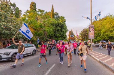 Hayfa, İsrail - 10 Mayıs 2025: İnsanlar savaşın sona ermesi, rehine anlaşmasının tamamlanması ve yeni seçimler çağrısında bulunan bir protesto yürüyüşüne (Pembe Cephe Grubu) katılıyor. Hayfa, İsrail