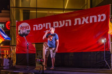 Hayfa, İsrail - 10 Mayıs 2025: Eylemci Dror Gavish, savaşın sona ermesi, rehine anlaşmasının tamamlanması ve yeni seçimler için düzenlenen protesto mitinginin bir parçası olarak kalabalığa sesleniyor. Hayfa, İsrail