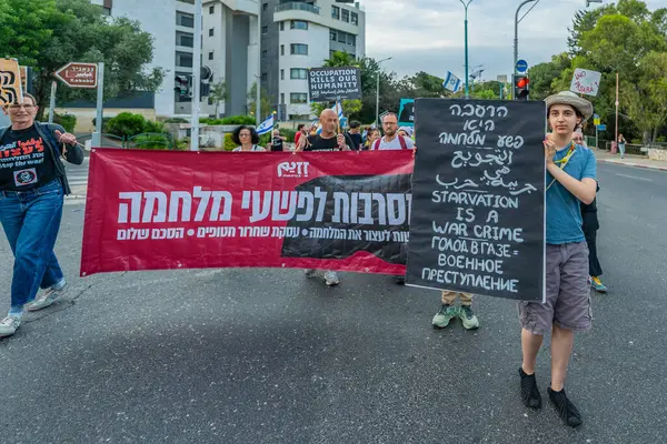 Hayfa, İsrail - 10 Mayıs 2025: İnsanlar çeşitli işaret ve bayraklarla bir protesto yürüyüşüne katılıyor, savaşın sona ermesi ve rehine anlaşmasının tamamlanması çağrısında bulunuyorlar. Hayfa, İsrail