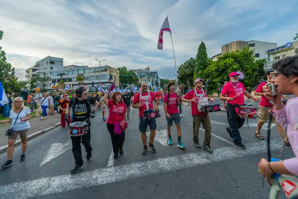 Hayfa, İsrail - 10 Mayıs 2025: İnsanlar savaşın sona ermesi, rehine anlaşmasının tamamlanması ve yeni seçimler çağrısında bulunan bir protesto yürüyüşüne (Pembe Cephe Grubu) katılıyor. Hayfa, İsrail