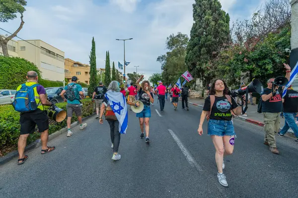 Hayfa, İsrail - 10 Mayıs 2025: Çeşitli tabelaları ve bayrakları olan insanlar, savaşın sona ermesi, rehine anlaşmasının tamamlanması ve yeni seçimlerin başlatılması için düzenlenen protesto mitingine katıldılar. Hayfa, İsrail