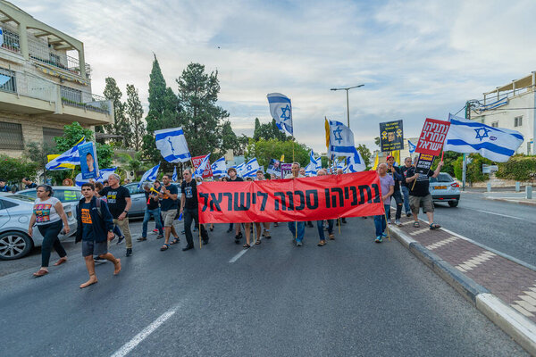 Haifa, Israel - May 10, 2025: People with various signs and flags take part in a protest rally calling for end the war, completion of the hostage deal and new elections. Haifa, Israel