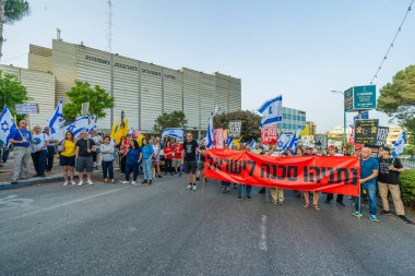 Hayfa, İsrail - 17 Mayıs 2025: Çeşitli tabelaları ve bayrakları olan insanlar, savaşın sona ermesi, rehine anlaşmasının tamamlanması ve yeni seçimlerin başlatılması için düzenlenen protesto mitingine katıldılar. Hayfa, İsrail