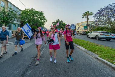 Hayfa, İsrail - 17 Mayıs 2025: İnsanlar savaşın sona ermesi, rehine anlaşmasının tamamlanması ve yeni seçimler çağrısında bulunan bir protesto yürüyüşüne (Pembe Cephe Grubu) katılıyor. Hayfa, İsrail