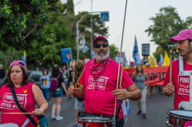 Hayfa, İsrail - 17 Mayıs 2025: İnsanlar savaşın sona ermesi, rehine anlaşmasının tamamlanması ve yeni seçimler çağrısında bulunan bir protesto yürüyüşüne (Pembe Cephe Grubu) katılıyor. Hayfa, İsrail