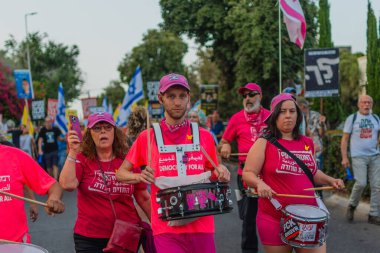 Hayfa, İsrail - 17 Mayıs 2025: İnsanlar savaşın sona ermesi, rehine anlaşmasının tamamlanması ve yeni seçimler çağrısında bulunan bir protesto yürüyüşüne (Pembe Cephe Grubu) katılıyor. Hayfa, İsrail