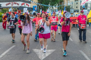 Hayfa, İsrail - 17 Mayıs 2025: İnsanlar savaşın sona ermesi, rehine anlaşmasının tamamlanması ve yeni seçimler çağrısında bulunan bir protesto yürüyüşüne (Pembe Cephe Grubu) katılıyor. Hayfa, İsrail