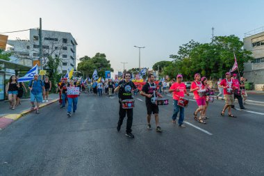 Hayfa, İsrail - 17 Mayıs 2025: Çeşitli tabelaları ve bayrakları olan insanlar, savaşın sona ermesi, rehine anlaşmasının tamamlanması ve yeni seçimlerin başlatılması için düzenlenen protesto mitingine katıldılar. Hayfa, İsrail