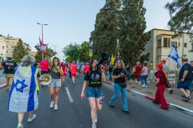 Hayfa, İsrail - 17 Mayıs 2025: Çeşitli tabelaları ve bayrakları olan insanlar, savaşın sona ermesi, rehine anlaşmasının tamamlanması ve yeni seçimlerin başlatılması için düzenlenen protesto mitingine katıldılar. Hayfa, İsrail