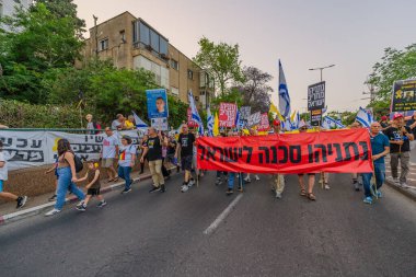 Hayfa, İsrail - 17 Mayıs 2025: Çeşitli tabelaları ve bayrakları olan insanlar, savaşın sona ermesi, rehine anlaşmasının tamamlanması ve yeni seçimlerin başlatılması için düzenlenen protesto mitingine katıldılar. Hayfa, İsrail