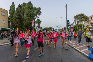 Hayfa, İsrail - 17 Mayıs 2025: İnsanlar savaşın sona ermesi, rehine anlaşmasının tamamlanması ve yeni seçimler çağrısında bulunan bir protesto yürüyüşüne (Pembe Cephe Grubu) katılıyor. Hayfa, İsrail