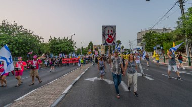 Hayfa, İsrail - 17 Mayıs 2025: Çeşitli tabelaları ve bayrakları olan insanlar, savaşın sona ermesi, rehine anlaşmasının tamamlanması ve yeni seçimlerin başlatılması için düzenlenen protesto mitingine katıldılar. Hayfa, İsrail