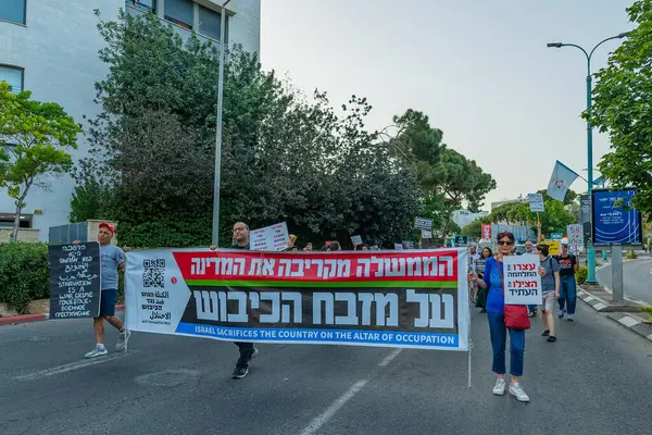 Hayfa, İsrail - 17 Mayıs 2025: İnsanlar çeşitli işaret ve bayraklarla bir protesto yürüyüşüne katılıyor, savaşın sona ermesi ve rehine anlaşmasının tamamlanması çağrısında bulunuyorlar. Hayfa, İsrail