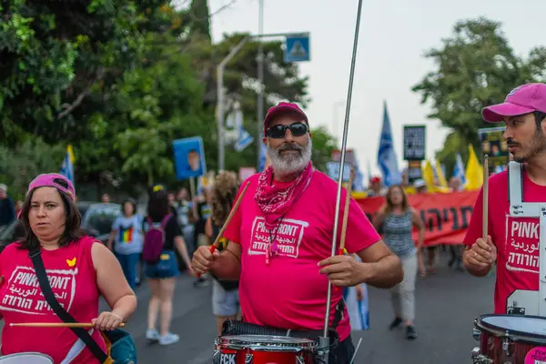 Hayfa, İsrail - 17 Mayıs 2025: İnsanlar savaşın sona ermesi, rehine anlaşmasının tamamlanması ve yeni seçimler çağrısında bulunan bir protesto yürüyüşüne (Pembe Cephe Grubu) katılıyor. Hayfa, İsrail